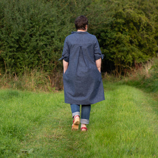 Female showing the back of the Emelia, A-line Dress sewing pattern in navy blue fabric
