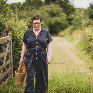 Female walking in the woods wearing the Cressida Jumpsuit sewing pattern